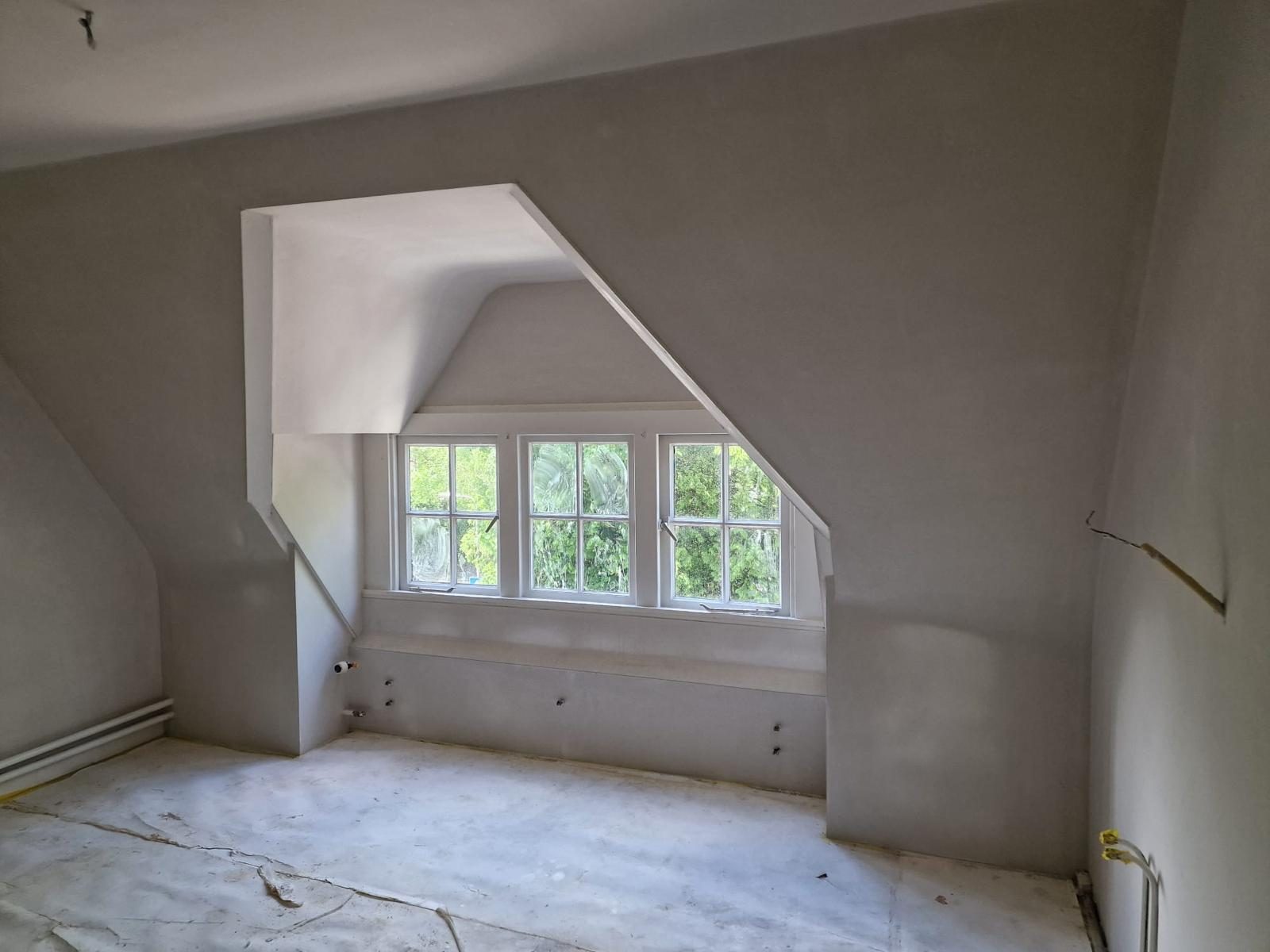 Lichte zolderkamer met strak gestuukt dakkapel en daglicht door Totaal Stucwerk
